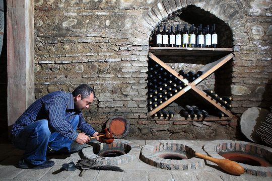 Gela Patalishvili, a wine engineer at the Pheasant's Tears wine cellar unseales and tries the wine from qvevri in Sighnaghi